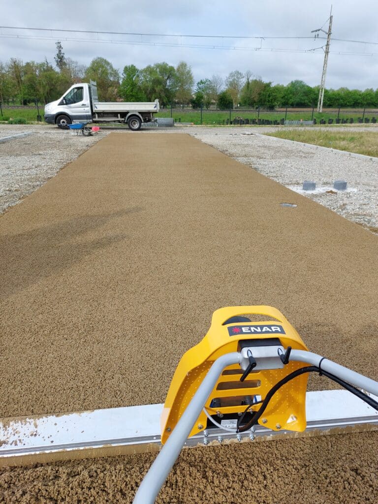 mise en place béton drainant avec règle vibrante à batterie